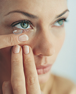 lady putting contact lense in eye
